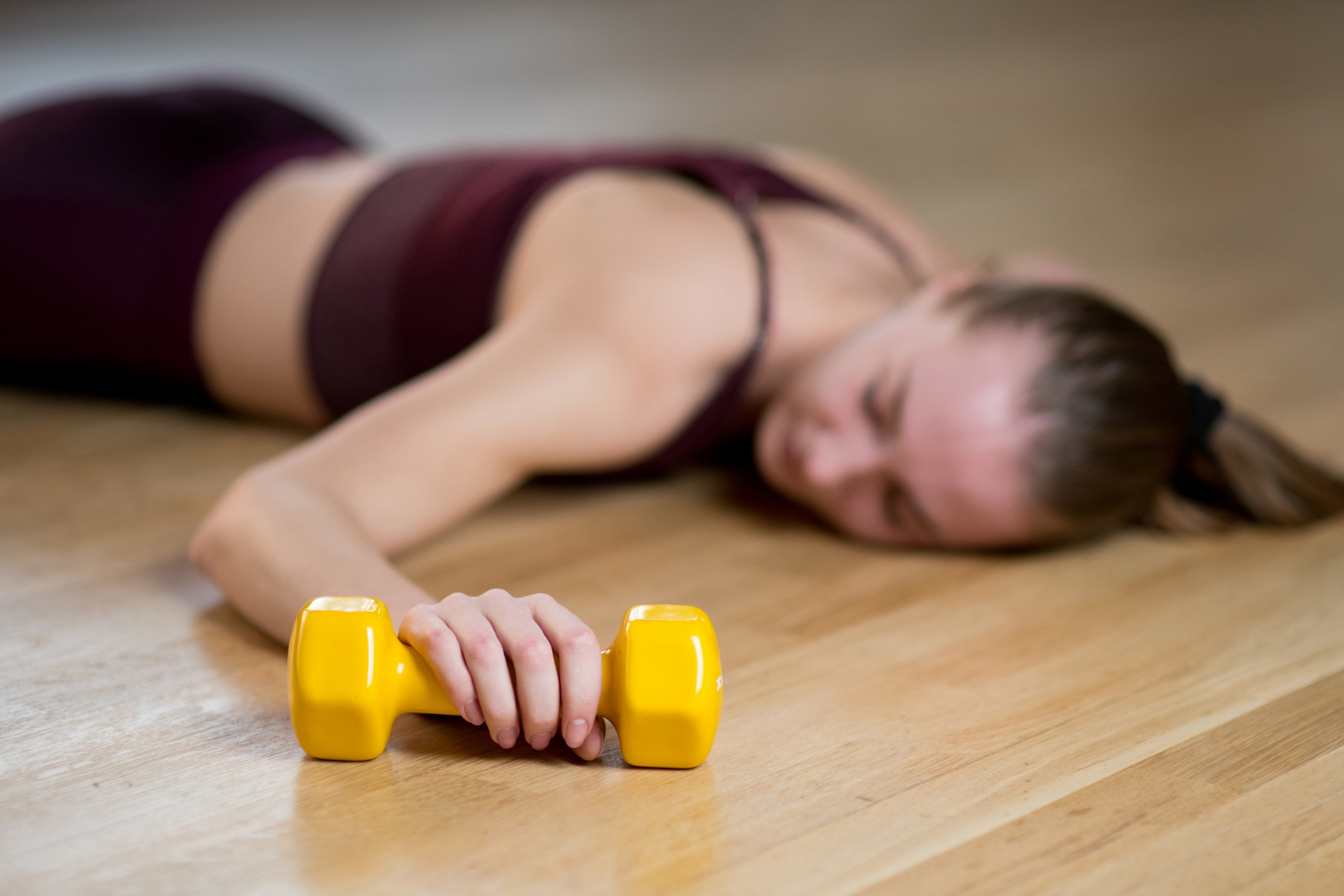 woman laying down holding a weight