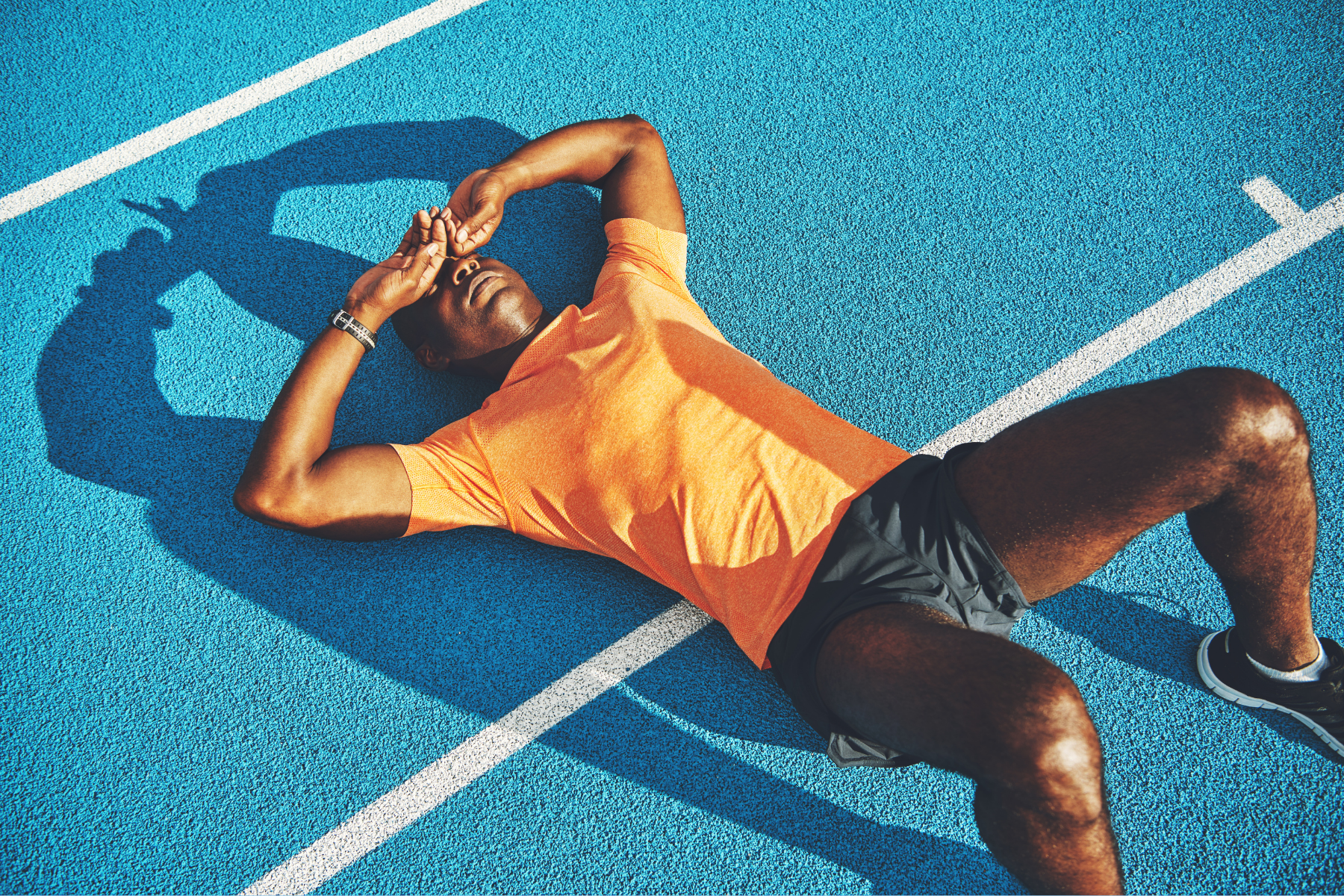 Runner tired and laying down on the track